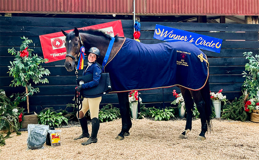 Girl posing in winners pit with her horse