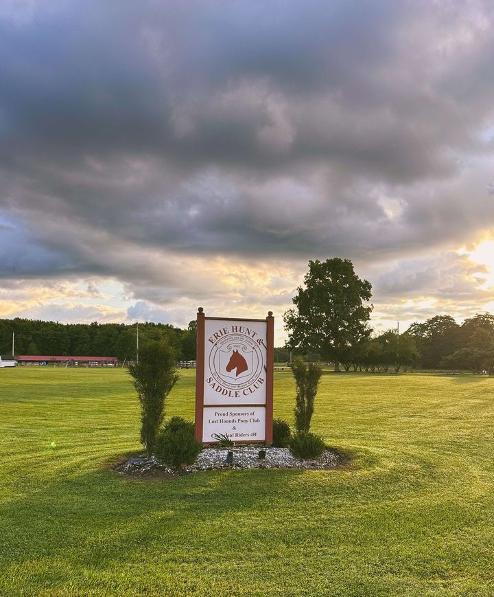 Erie Hunt and Saddle Club Sign with clouds behind it