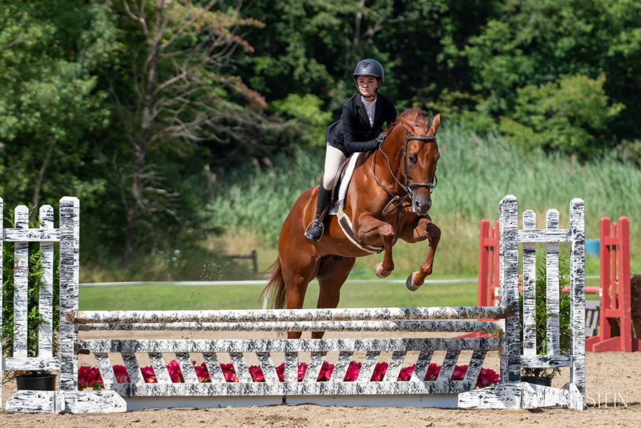 Girl riding horse jumping